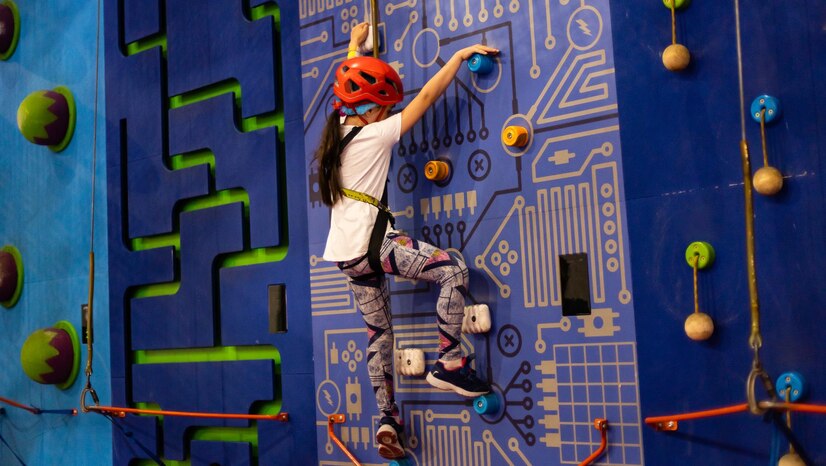 a child climbing a wall at an indoor climbing gym