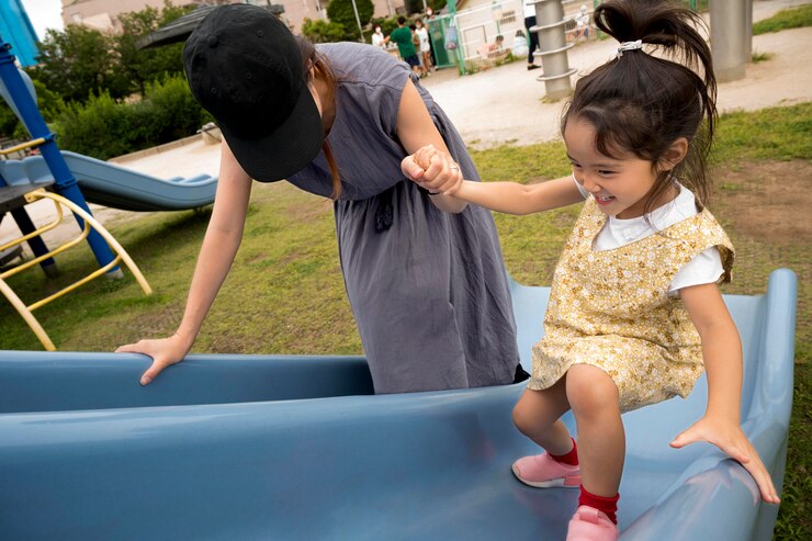 a parent playing with their daughter at a park