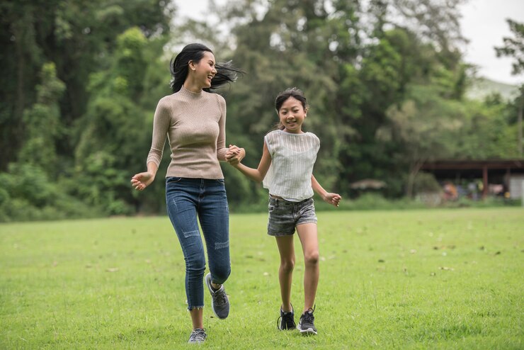 a mother and daughter running together in a park