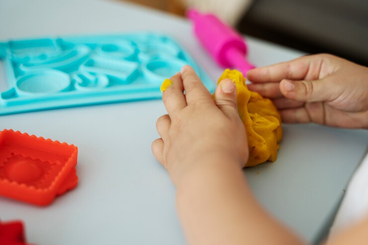 a child making shapes from modelling clay